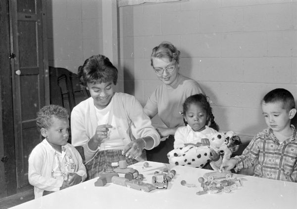 Students from Edgewood College assist Donna Jones, director of the Blessed Martin House nursery school, which will benefit from the annual bazaar of the De Porres guild. Participants shown, left to right, include: Miguel Marques, Loyce Frilot (Edgewood assistant), Donna Jones (director), Damita Lewis, and Michael Jones.