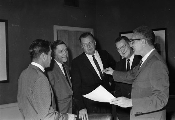 Leaders of the National Sales Executives Club of Madison go over plans for the annual fall sales rally. Left to right: Ernest Haar (Ray-O-Vac), Harry Manzer (Washington National Insurance), John Schultz (Research Products Corp.), Owen Slauson (Ray-O-Vac), and A. J. Hancock ( Wisconsin Life Insurance).