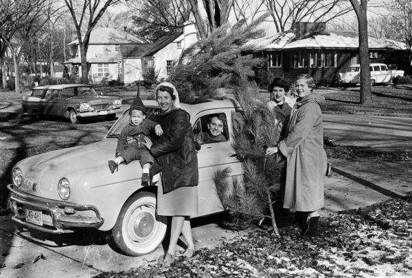 Service league members of Christ Presbyterian Church prepare their "Home for the Holidays" tour, boutique, and bake sale. Many of the items to be shown in the home tour will suggest things to make for Christmas. Some service league members are Betty Stroud holding her son Peter, and, left to right, Margaret Stroud , Amy Shumway and Joyce Weston.