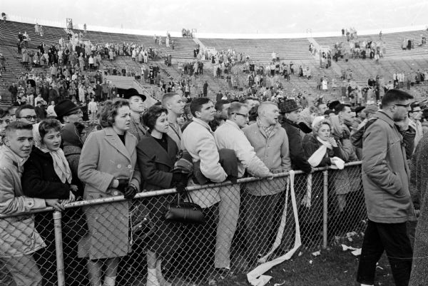 The University of Minnesota football team beat the University of Wisconsin Badgers 26-7. The victory gave the Minnesota Gophers a tie with Iowa for the Big 10 championship, the first for the Gophers since 1941. Spectators watch as the steel frame holding the ball-catching net of the goalpost falls injuring Lorin Daggett, a fifteen-year-old West High School student.