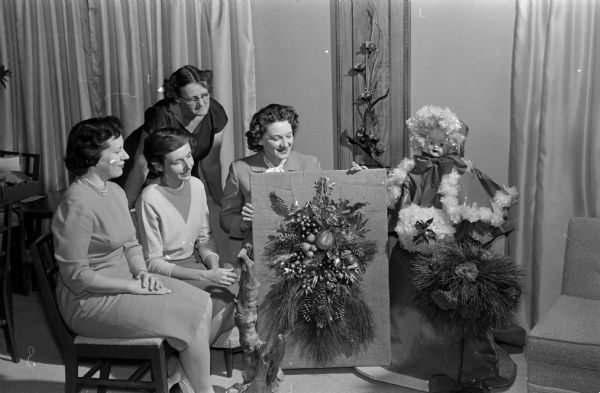 Shown discussing an arrangement for the Christmas flower show of the Mendota Gardeners are, left to right,  Viola Keller, Fay Stephenson, Ruth Bass (standing), and Margo Barron.