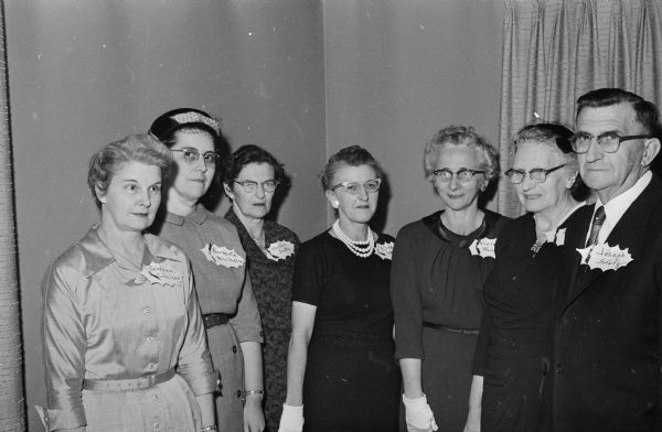 Group portrait of Madison General Hospital employees who received service pins at a special recognition dinner. All served 15 years, except Elva Mills (center) who completed her 20th year. Shown left to right: Genevieve Scheiber, Bernetta Michels, Merian Smith, Elva Mills, Vivian Henning, Lillie Fessler, and Joseph Statz.