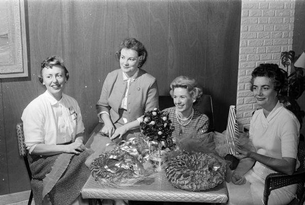 Members of the newly formed American home group of the Junior Women's Club of Madison are making Christmas trees and wreaths for rooms of the patients at the Wisconsin Neurological foundation. Shown working on the project are Brenda Kerrigan, Merrilyn Wegner, Mary Royston, and Virginia Christensen.