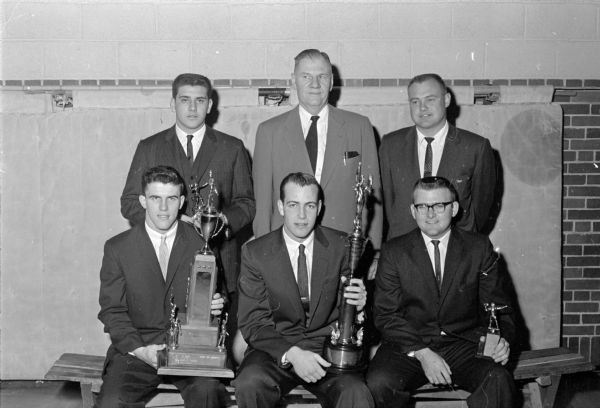 Group portrait of speakers and special award winners at the Edgewood High School football banquet.  Front row: Tom Brophy with Dave Sanna trophy; Tom Yaudes with Tom McCormick trophy and Mike Corcoran with most valuable player award.  Back row: Joe Provenzano, co-captain; Earl Wilke, head coach; and Darel Teteak, University of Wisconsin assistant coach.