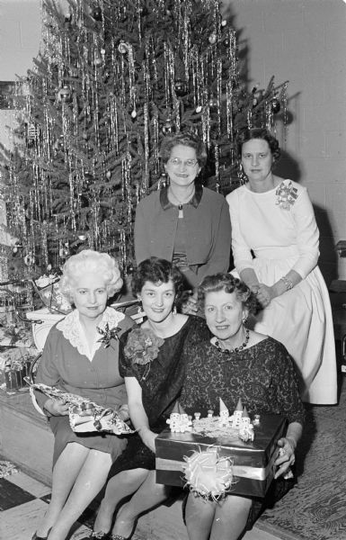 Members of the East Side Women's Club bring gifts to the club's Christmas party for the children at the Morningside Sanatorium, a tuberculosis treatment center. From left to right are: Hazel Van Wagenen, party chairman; Marilyn Lindau; and Hazel Spink, assistant superintendent of the sanatorium. Delores Peck and Lena Lerdahl are in the back row.