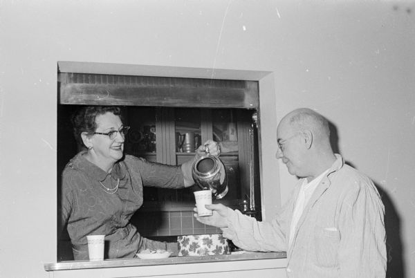 B'nai B'rith women provide coffee and cookies for patients and their families and friends on Christmas Day at the VA Hospital. Edith Rubenstein is shown giving a cup of coffee to Edward S. Wilson.