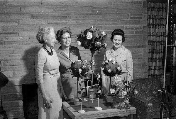 Three members of the University League look over the decorations for the annual dinner-dance and bridge party.  Left to right:  Doris Green, Mary Mohs, and Genevieve Busse.