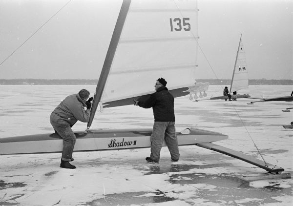 Bloop Polglase and John L. Bluel make last-minute checks on their iceboat prior to the Four Lakes Club races on Lake Monona.