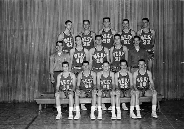 Group portrait of the Madison West High School basketball team. First row, left to right: Steve Best, Tom Speranza, Neal Ruedisili, Jeff Bartell, and Ken Waggoner. Second row, left to right: Manager Ron King, Don Pfahler, Henry Cuccia, Terry Johnson, and Manager Dan Aspinwall. Third row, left to right: Mike Moore, Bill Marlin, Ralph Farmer, Ken Kappel, and John Mitby. Not pictured: Harry Kingsbury.