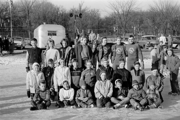 Group portrait of 23 young ice skaters who all won championships in the 1961 city speed skating meet at Vilas Park.
