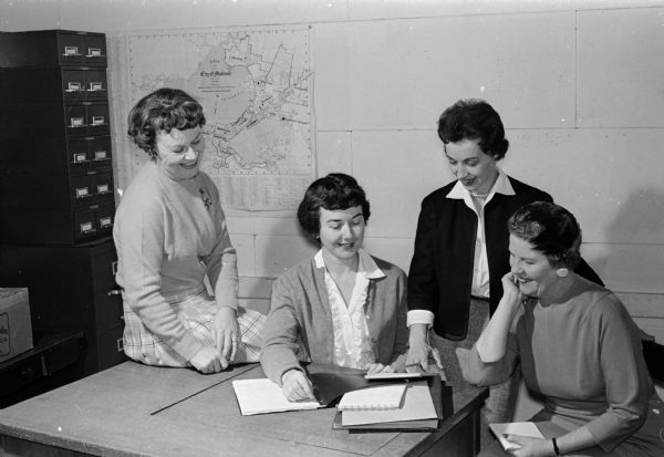 A committee begins to plan Madison Women's 1961 City Golf Tournament at the Community Center. Shown (from left) are: Mrs. Jane Brandt, Public Links Courses; Mrs. Jean Watkins, committee chairman, Maple Bluff Country Club; Mrs. Arlene Viereg, Blackhawk Country Club; and Mrs. Cappy Molinaro, Nakoma Country Club.