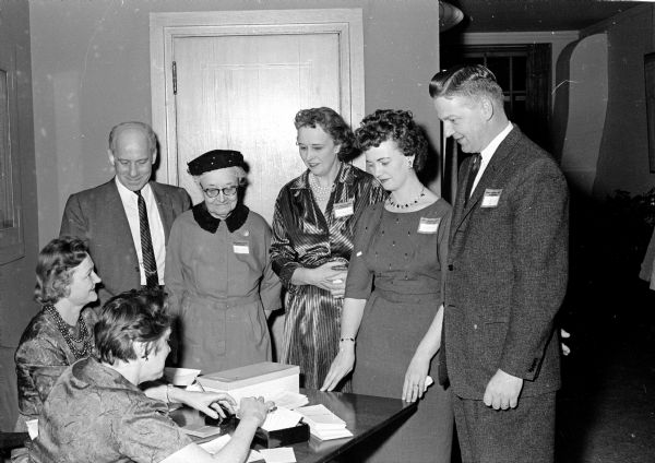 Lois Elsener, left, and Mary McCann, both business office employees, take reservations from a group that includes, left to right, Walter F. Scott of the Society's conservation department; Isabel Ebers and Mrs. Harry Kelk, both of Lake Tomahawk, and Darlene Behnke and Leonard Behnke, the comptroller of the Society.