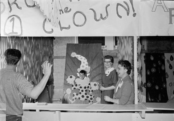 Zonta Club members Jane Mittelstaedt and Cecetia Mullins watch as a patient at the Mendota State Hospital tries to "hit the clown" with a rubber sponge during the Club's annual winter carnival for patients.