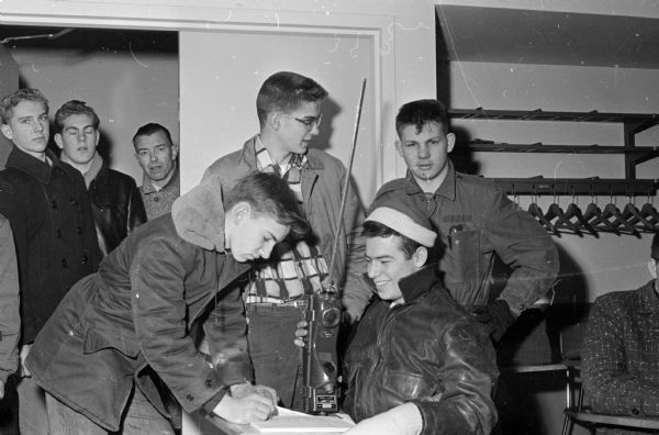 Four Explorer Scouts test a "walkie talkie" and sign in for "emergency duty" in a search test. Left to right: Larry Peterson, Sterling Miller, Dick Sullivan, and Dennis Fitzgerald.
