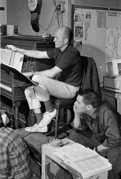 Two men at podiums watch a rehearsal. At upper left is Marvin Foster, musical director and orchestra leader. At lower right is Al Barraclough, managing director of the Guild and director of the musical, 'Carousel'.