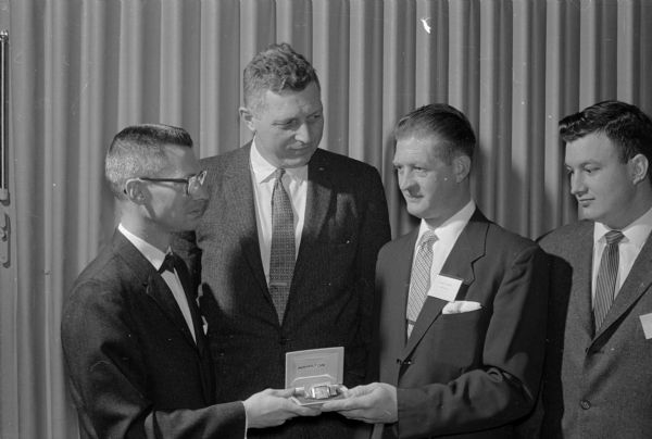 Kenneth Volkmann, third from left, chosen outstanding apprentice of the year, receives an engraved gold watch from John Clark, left, president of the Madison Mechanical Contractors Association. E.R. Stege, second from left, executive secretary of the association looks on. The man on the far right is unidentified.