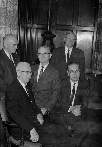 Five retiring key men in the State Department of Public Instruction are honored at the annual spring banquet of the Wisconsin Association of Secondary school principals. Seated left is Russell F. Lewis, first assistant state superintendent. Seated right is State Supt. George E. Watson. Standing, left to right, are: Victor E. Kimball, who is in charge of school district reorganization and school transportation; Walter B. Senty, who is in charge of National Defense Education Act funds in Wisconsin; and Arthur R. Page, who is in charge of school administration.