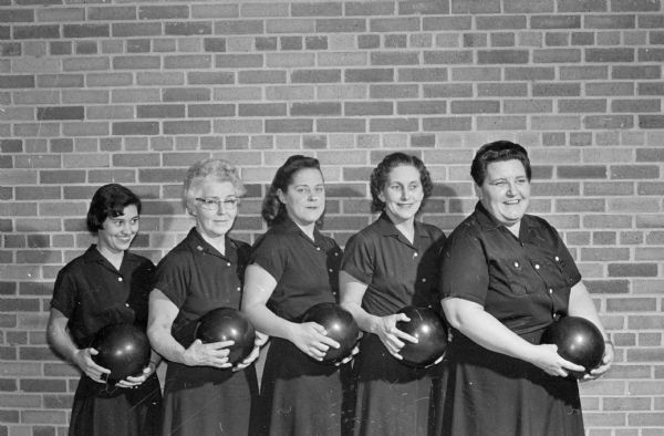 Indoor group portrait of the Madison Dream Lanes bowling team, which set the team scoring pace in the 42nd annual state women's bowling tournament. They scored 2,668 last Saturday at Burr Oaks Bowl. The team also competes under the Wisconsin-Felton Sporting Goods banner, and leads the Ladies Major League at the Bowl-A-Vard. Left to right are: Nan Adler, Lorene Keefe, Audrey Geier, Dee Fix, and Kelly Butterworth.