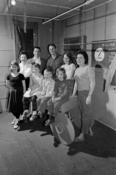 Portrait of family members in the Madison Theater Guild cast of "Carousel". Shown in the front row, left to right, are: Debbie Foster, dancer; Frances Fetherston, dancer; Jonathon Fay; and Debbie Fay. Shown in the back row (L-R) are: Kay Fetherson, singing chorus; Frank Fetherson, playing the part of Jigger; Noel Thompson, singing chorus; and Elaine Thompson, singing chorus.
