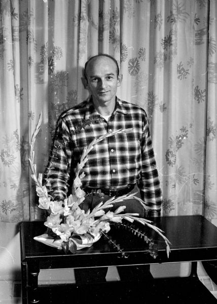 This year's Madison Vocational and Adult School's evening flower arranging classes are full with 80 students enrolled, including two men.  For the class show Raymond Vollbrecht of Columbus created a crescent design using pickardy, gladioli and eucalyptus leaves.