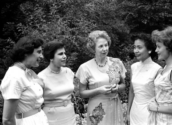 The Madison branch of the Women's International League for Peace and Freedom hold a tea at the home of UW Professor Karl Paul Link to observe the centennial of Jane Adams who founded the league in 1915. Special guests at the tea are foreign women living in Madison. Shown (L-R) are: Mrs. Grace Iltis, member of the invitations committee, Israel; Mrs. E.J. Trowbridge, member of the refreshment committee; Mrs. Ernest Kung, Formosa; and Mrs. Bjorn Odegard, Oslo, Norway.