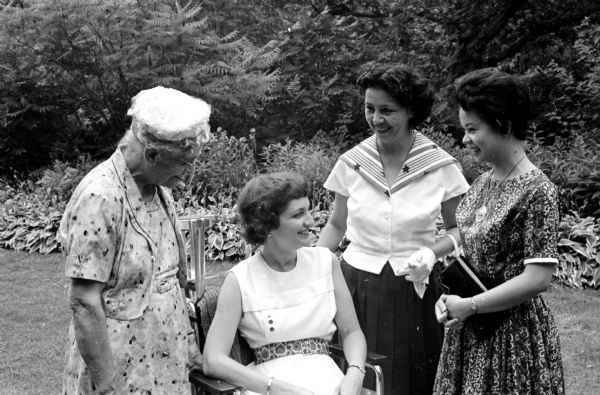 The Madison Branch of the Women's International League for Peace and Freedom entertains foreign women living in Madison at a garden tea, honoring the centennial of Jane Addams who founded the League in 1915, at the home of Mr. and Mrs. Karl Link. Shown (L-R) are: Mrs. Grace Rosa; Mrs. Emory Via, tea chairman; Mrs. Betty Barrientos, Bolivia, and Mrs. Elenita Ordonez, the Philippines.