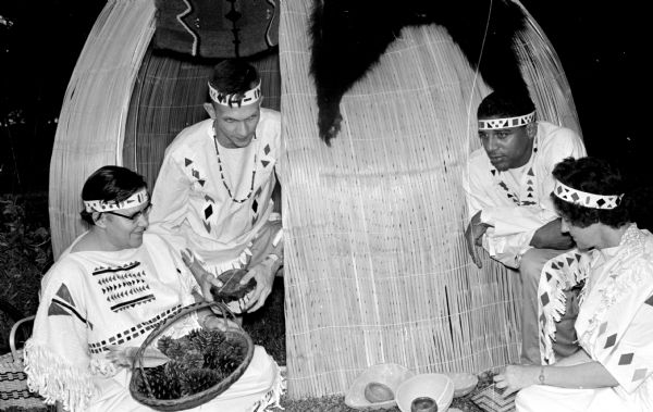 Several participants tell the early history of Mendota State Hospital at the centennial pageant. They are, left to right: Cecilia Shedleski, a nurse at the hospital; Michael O'Connell and Clyde Elvord, both aides, and Helen DeBardeleben, a social worker, gathered around an Indian wigwam.