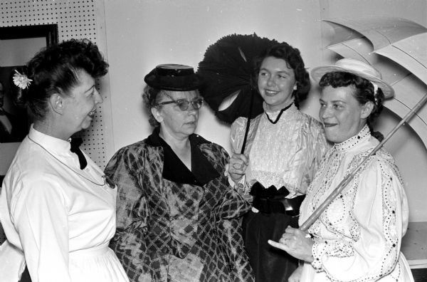 Employees dress in turn-of-the-century dresses for a scene in a centennial pageant depicting nursing at Mendota State Hospital. The costumes were from the State Historical Society and the Milwaukee County School of Nursing. Left to right are: Mary Reublin, dietitian; Catherine Jordan, head nurse; Dessa Cassens, medical records department; and Sylvia Martinson, practical nurse.