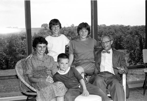Edwin Bruner, the new Family Court Judge, who will take his oath of office Friday morning, is shown with his family in the glass-enclosed living room of their self-renovated old farmhouse southwest of Madison. Standing beside Mrs. Bruner is their daughter Cathie; next to her Mary and, in front, Jeff.