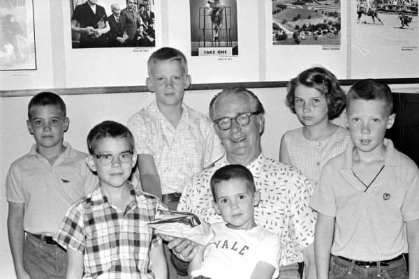 These children donated $3.16, the proceeds from a carnival they held in the backyard of the Hirsch residence to Roundy's Fun Fund for handicapped and underprivileged children. Back row left to right: John Hirsch, David Roark and Janet Hirsch. Front row left to right: David Tipple, Steven Rodgers (on Roundy's lap) and Chris Rodgers.