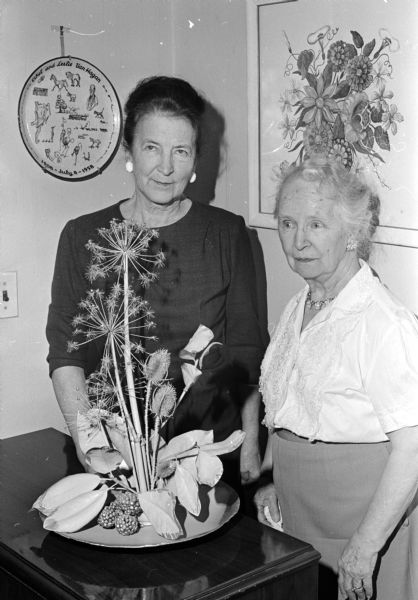 Mrs. Charles Sakrison of Middleton, left, chairman of the Flower Show School, Course III, to be sponsored by the West Side Garden Club, examines an arrangement with Ethel Van Hagen, club president.
