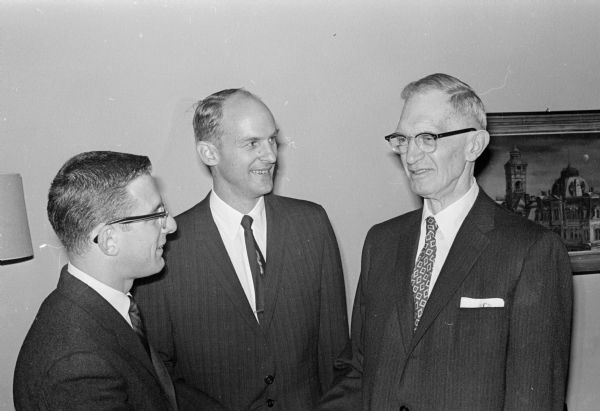 Sigma Delta Chi president Henry Feuerzeig, left, talks with journalism professor Frank Thayer, right, the guest of honor at fraternity's gridiron banquet. Professor Thayer was presented the Red Derby Award and has been the chapter's adviser since 1937. Also in the picture is Edward W. Scripps II, vice-president of Scripps-Howard Newspapers, and the featured speaker.