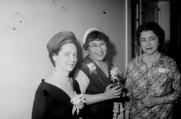 Ethel Parker, center, holds the Writer's Cup which she was awarded for outstanding work in communications at the annual Ladies of the Press breakfast. Ethel is the public relations director of the Dane County chapter of the American Red Cross. On the left is Jean Mooney, Cleveland, Ohio, and right, Dorothy Lindquist, toastmistress for the breakfast.