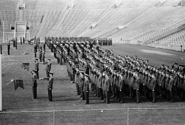 Group portrait of about 1000 UW student cadets and midshipmen posed in formation inside Camp Randall Stadium for the presidents annual military review. 63 ROTC cadets received special awards.