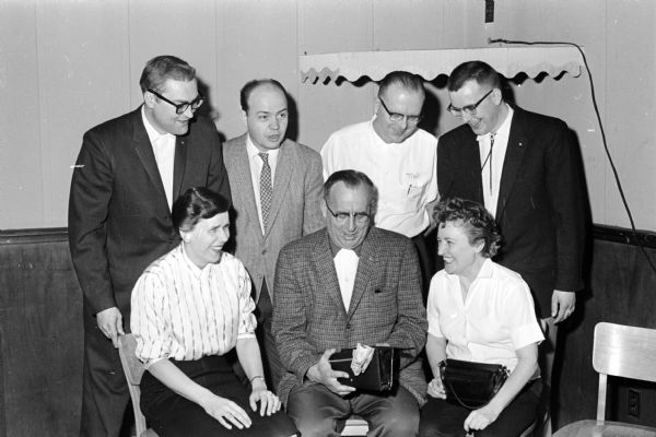 Bowling officials and bowlers gather at the "Champion of Champions" annual bowling tournament at the Plaza Alleys in Madison. 
Shown seated (left to right) are: Lil Schroedl, president of Madison Women's Bowling Assn.; Frank Gottsacker, master of ceremonies; and Mercedes Dufour, member of the Cuff's team, winners of Unemployment Compensation League.
Standing (left to right) are: Rollie Harris, co-secretary of Madison Bowling Assn.; Don Wichers, president of the Madison Bowling Assn.; Mel Schwoegler, captain of Rendezvous team, winner of the MBA tourney; and Bill Schwoegler, co-secretary of the Madison Bowling Association.