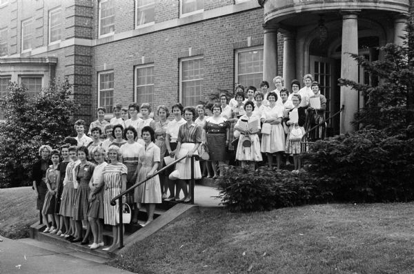 Forty-three nursing students in the Madison General Hospital School of Nursing Class of 1963 begin the two-year clinical phase of their nursing education. Members of the class are shown posing in front of the hospital.