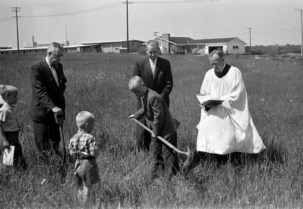 Bobby Stolen, a member of Grace Lutheran Church, turns a spadeful of dirt at the groundbreaking ceremony for the Grace Lutheran Church at Rosa Road and Regent Street. Looking on are, left to right: O.M. Wilson, lay member of the Lutheran Synod's mission board; Roy Evans, church officer and the Rev. Wilhelm Petersen, pastor.