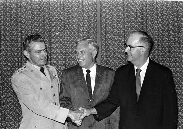 Major General James C. Jensen is congratulated by Madison mayor Henry Reynolds, center, and president of the Chamber of Commerce Dorsey Botham at a farewell luncheon. Jensen has been commandant of the 30th Air Division of the North American Air Defense (NORAD) since the division was established in Madison in 1959. He is leaving to become vice-chief of staff of operations, Air Defense Command, at Colorado Springs, Colorado.