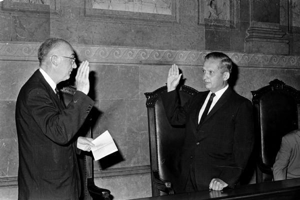 Angus B. Rothwell, right, is sworn into office as the new Wisconsin State Superintendent of Public Instruction by Supreme Court Justice George Currie at the State Capitol.