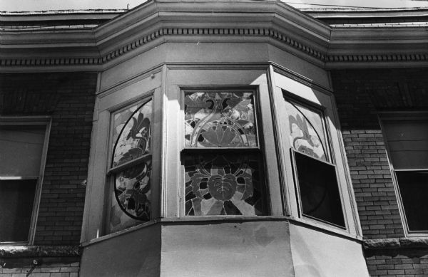 Stained glass bay window in a second story apartment at 702 University Avenue. The building was originally owned by H.V. Teckam, and built in 1899. For many years the first floor of the building was the home of Tiedeman's Drug Store and Grill.