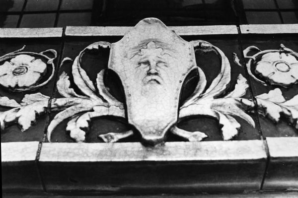 Terra cotta detail of a man's face and floral design on the front of Castle and Doyle Coal Company at 125 State Street.