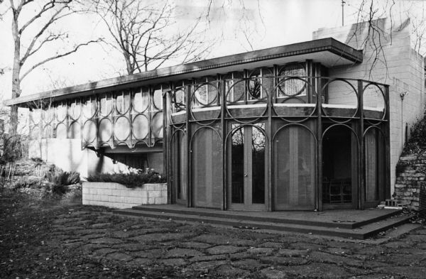 Multi-colored panels with a circular motif, designed by the Taliesin Fellowship, at the home of Dr. Walter Plaut, a University of Wisconsin-Madison zoology professor, 302 Shepard Terrace. The circular motifs above the veranda are purely decorative, but those under the roof serve as a truss support.
