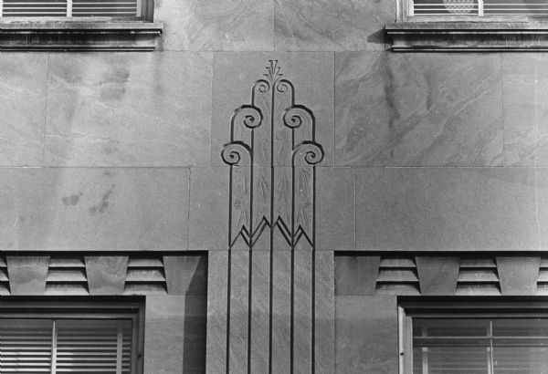 An intricate design carved into the side of the building at 102 N. Hamilton Street. The building was built for Montgomery Wards (1929-1942); occupied by USAFI, the United States Armed Forces Instititute, (1942-1968); became an office building (1969-2009); and now is the Madison Children's Museum (2010 -    ).