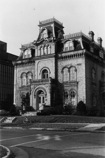 Exterior view of German Romanesque revival brick house built in 1857 with a Second Empire-style mansard roof added in 1870, 28 East Gilman Street in the Mansion Hill neighborhood. Designed by August Kutzbock for Napoleon Bonaparte Van Slyke who never lived there. Dr. George Keenan, a prominent Madison physician and United States consul to Kiel and Bremen, Germany, and his wife, Mary, lived in the house from 1900 to 1916.