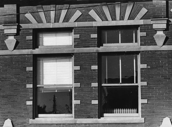 Two ornamented windows at the Central Madison Fire Station, 18 South Webster Street. The lintel (the brick and stone arch) above the second story windows is decorative, with a functional steel lintel behind it for support.