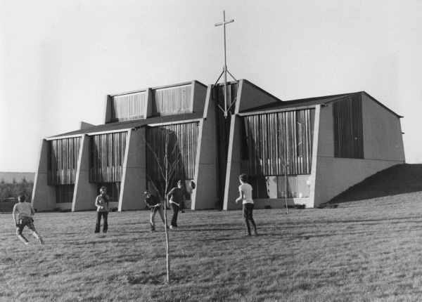 Exterior view of Divine Saviour United Methodist Church at 6402 Hammersley Road, featuring colored glass windows with redwood paneling.