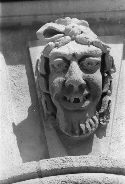 Stone carved head detail on the Beta Theta Pi House at 622 Mendota Court.