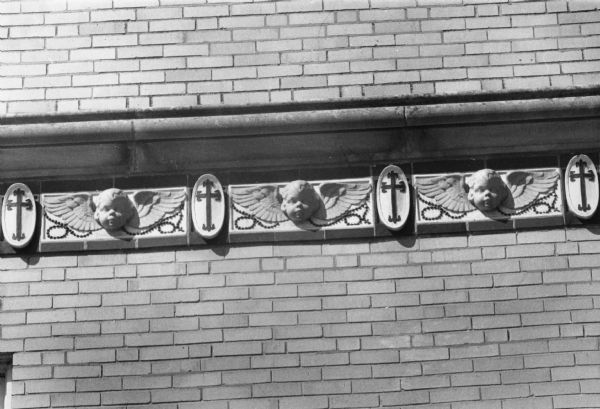 Religious details on an Edgewood College building including cherubs, crosses, and actual rosaries embedded in the design.