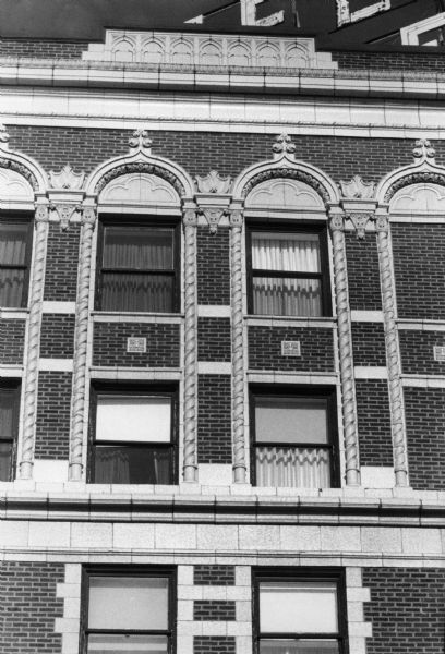 Ornate window details and brickwork patterns on the exterior of the Hotel Loraine at 123 West Washington Avenue.