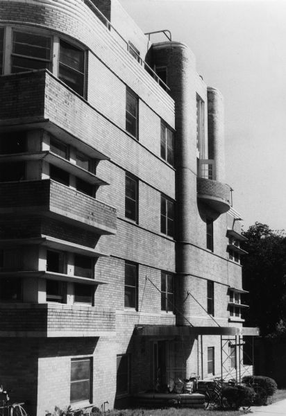 Exterior view of the Art Moderne Quisling Towers Apartments at 1 East Gilman Street, featuring sharp ledges and curved towers, designed by Lawrence Monberg.